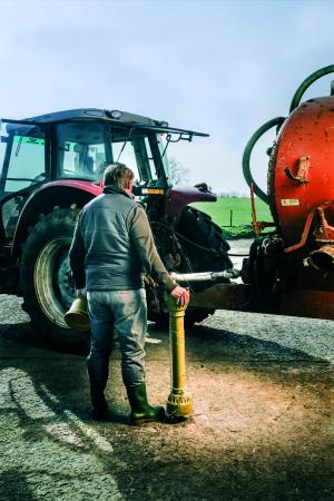Image showing a farmer standing in front of a tractor